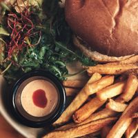 Burger aux champignon shimeji panné, mayo sriracha, aubergines, roquette, coriandre et pickles de moutarde avec frites et salade at Mōpa in Paris