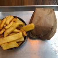 The yummy French fries (you can squirt a condiment on top of them, my choice was, of course, ketchup) and the Hatake burger in its wrapping. at Mōpa in Paris