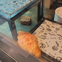 Fallen croissant and flapjack in the display cabinet. at Caffè Nero in Sherborne