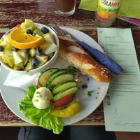 Bread, vegan butter, some veggies and a bowl with fruit, soy yogurt and oats at Kult in Wurzburg