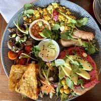 Scrambled Tofu Full Breakfast: with vegan sausage, tamari mushrooms, beans, tomatoes, spiced chickpeas, beetroot hummus and avocado hummus, hash browns and salad leaves    at Bio Cafe in Aberdeen