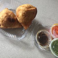 Vegetable Samosas with pickled onions, Tamarind, and Coriander sauces on the side  at Mumbai Masala in New York City