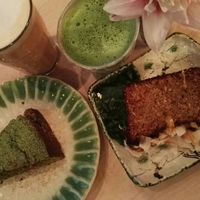 Matcha latte, chai latte with almond milk, matcha cake and mango coconut cake at Tushita in Munich
