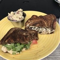 Half a chickpea salad sandwich on left, half a Reuben on right. Potato salad side at rear. at Leaf & Lentil in Sarasota
