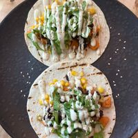 Sweet Bean Tacos
2 soft tortillas filled with organic black bean dip, guacamole, corn, sweet potato, pickled jalapeños, and topped with cashew sour cream and arugula  at Nourishmoi in Mississauga