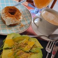 Tostada con aguacate y sirope de mango, dulce de lotus vegano, zumo de naranja natural y café con leche de soja at Cafe La Lola  in Gran Canaria
