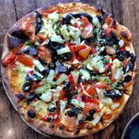 Supreme pizza with vegan cheese - tonnes of olives and pineapple (which does belong on pizza) at Scoozi in Picton