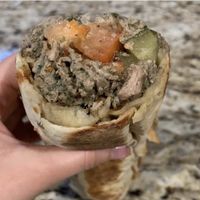 The impossible sandwich with impossible “meat”, hummus, tomato, onion and pickles wrapped in oven-fired flatbread.  at Furn Saj Restaurant & Bakery in Granada Hills