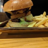 Burger includes vegan cheese, hash brown, onion rings and BBQ sauce, with chips at Harvester in Dudley