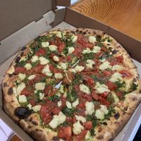 Pesto and fire roasted tomato pie with vegan cheese made in housee  at Abbondanza in Ucluelet