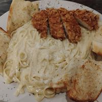Alfredo pasta with garlic bread and optional crispy chick'n at Plant Based Mafia in Palm Beach Gardens