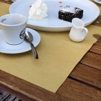 A chocolate brownie with cream (all vegan) with espresso and rice milk (as recommended by staff instead of soy milk, which negatively impacts the flavour of the coffee).  at Cavo Bistrot in Cagliari