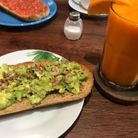 Tostadas con aguacate y semillas y zumo at La Trastienda Cafe in Alcoi