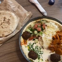 Hummus with falafel, seasoned carrots, warm pita, and more  at Hummus Bar - Király Utca in Budapest