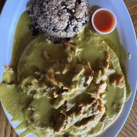 Green chili pinto bean pupusa topped with green chili sauce and soy curls  at Monse's Pupuseria in Colorado Springs