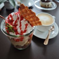 Erdbeerbecher mit Grießbrei-, Milchreis- und Schokoeis, und Cappucino at Eisdiele Frohnatur in Kassel