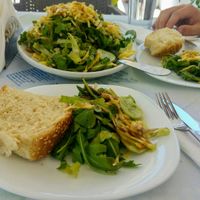Salad with different green leaves, cucumbers, onions and vegan cheese at Ammos in Crete