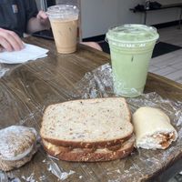 Left to right: oatmeal whoopie pie, bbq tempeh sandwich, pepperoni roll, Fairy Brew matcha lattee  at Quantum Bean Coffee in Morgantown