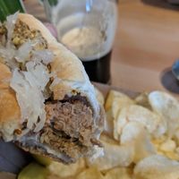 Vegan beyond meat bratwurst with sauerkraut on a vegan bun from Cobbs, served with chips. Yum! at White Sails Brewing in Nanaimo