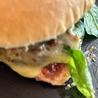 Part of a Pizza Burger involving a Beyond Meat patty, fresh baby spinach and sun-dried tomato  at PEACH in Newport