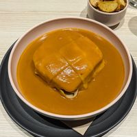 Francesinha with seasoned fries at Kind Kitchen in Porto