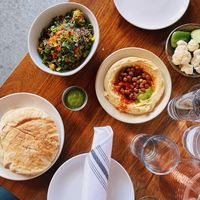 Warm pita bread, Avocado crispy rice, hummus, veggie plate, side of schug. at Butcher & Bee in Nashville