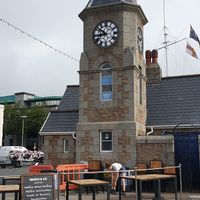The restauranr is inside this building surrounded by its outdoor seating. at Waffle and Co in Guernsey