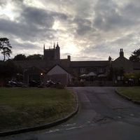 External of pub with church in background at Ring O' Bells in Paulton