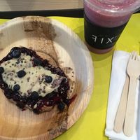 Toast with blueberry jam, nut butter, raw chocolate and dragonfruit and coconut smoothie  at DXB - FIX - T3 - B3 in Dubai