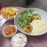 Roasted carrots with vadouvan and scallions, avocado-lime sauce, coconut flakes and cress. Served with fries with vegan mayo. at VRIENDSCHAP in Middelburg