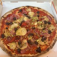 Veggie Supreme pizza topped with tomato sauce, caramelized onions, olives, artichokes, dried cherry tomatoes, and pistachios  at Da Michele in Venice