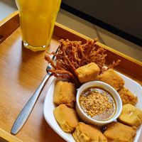 Fresh orange juice and fried tofu with satay sauce. at Minf Houze Vegan Cafe in Kuala Lumpur