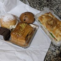 Izq>der: Brownie, bomba crema, napolitana de pistacho, doowap y focaccia de hummus, rúcula y pimientos del piquillo at Dolce Capriccio Pasticceria in Oviedo