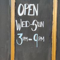 Opening hours painted on the entrance door at Earth's Kitchen  in Birmingham