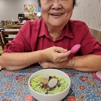A happy mom with bowl of cendol with attap seeds at Warung Ijo in Central Singapore