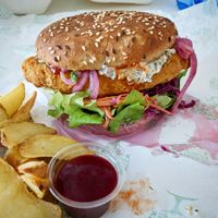Vegan "fish" patty, pickled gherkin tartar, cabbage and carrot coleslaw with sriracha mayo, onions and tomato. I had wedges and beetroot ketchup with it too.  at RoseHip Bistro - Pylimo in Vilnius