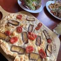 Veganer flammkuchen, Salat und im Hintergrund Veganer Burger mit Pommes und Salat   at Scheune Biber Ferienhof in Mirow