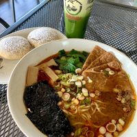 Spicy miso ramen with no egg and sweet tofu, iced matcha with oat milk and red beans pancakes    at Cravings Deli in Portage