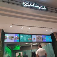 underneath the schnitzel sign at Vedang - green burger | Alexa in Berlin