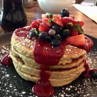Apple-almond oat pancakes with berry sauce and fresh mixed berries at Petisco Vegano in New York City