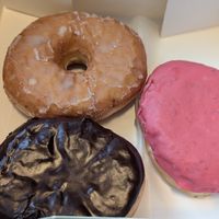 Boston Cream on the bottom, glazed on top, cheesecake donut with raspberry frosting on the right at bloomer's in Toronto