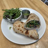 Mediterranean Wrap- hummus, spicy herb sauce, red pepper pistachio spread, cucumber, olives, artichoke, organic spring mix, lemon oregano vinaigrette. Side salad included.  at True Food Kitchen in Jacksonville