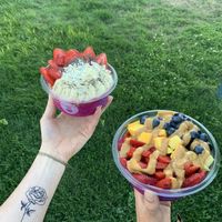 Pitaya bowl with vegan vanilla protein powder, bananas, strawbs, coco flakes, and chia seeds: Green bowl with strawbs, blubes, mango, and a peanut butter drizzle at Playa Bowls in Brighton