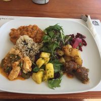 Platter of a soy meatballs with patatas bravas, tofu maqueca and beans and vegan sausage with rosemary (with rice and a salad). at M Butterfly by Miss Saigon in Lisbon