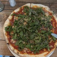 Fresh Pizza with corn, onions and arugula. Cashew Parmesan on top  at Pizzamacherei in Hamburg
