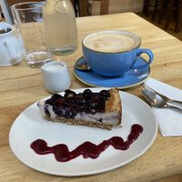 Vegan blackcurrant cheesecake & oatmilk lattee  at Goji Vegetarian Cafe and Deli in York