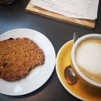 A vegan granola cookie and oat milk latte (I has already taken a bite from the cookie). at Temperance in Halifax