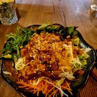 Rice noodles with veggies and tofu topped with several toppings at Soy in Munich