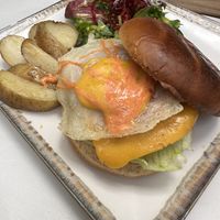 Fried egg and bacon cheeseburger on brioche bun  at Veganitessen in Sevilla