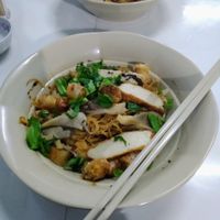 Fried noodles with mushrooms, moch meat, fried spring roll bits, veggies and herbs. at Com Chay 33 in Kon Tum